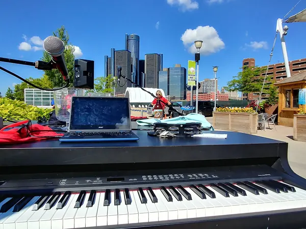 Outdoor dueling piano setup in downtown Detroit with the skyline behind