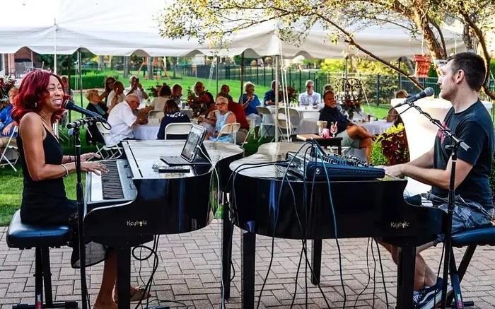 Dueling piano player performing on a grand piano at a Michigan event