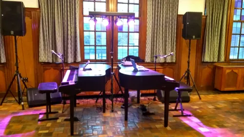Two grand pianos ready for a show in a historic hall