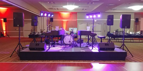 Dueling pianos with drums on a ballroom stage