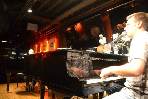 Dueling piano player performing on a grand piano